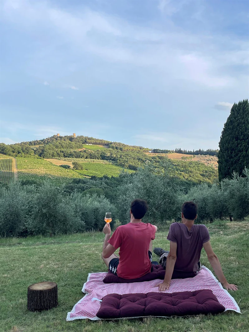 Coppia brinda con un calice davanti alle colline di Montespertoli