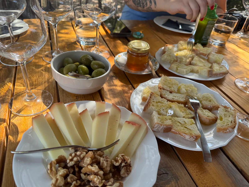 Tagliere della degustazione: formaggio, noci, olive, miele e crostini all'olio